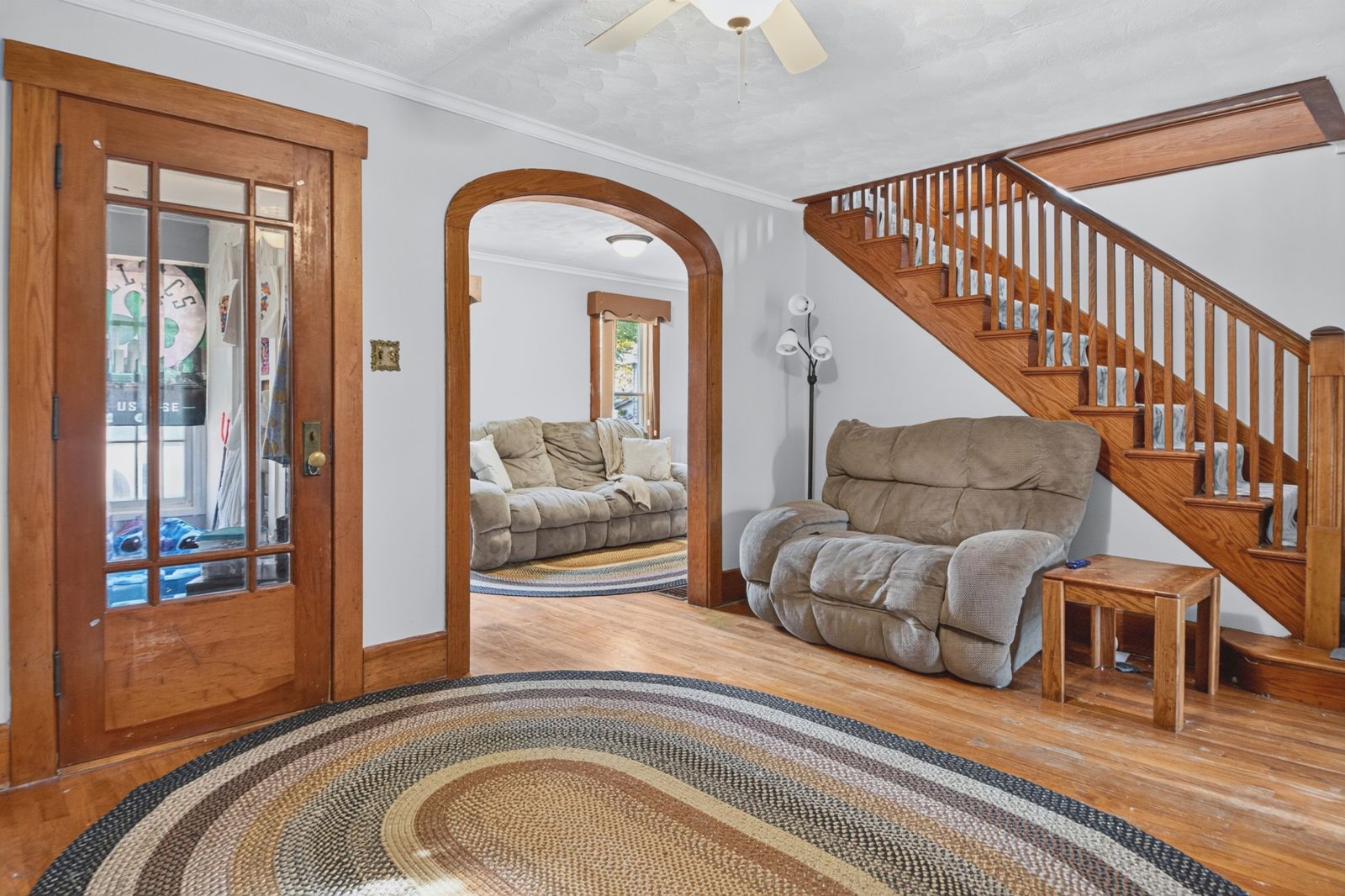 Entry with hardwood floors, arched doorway and staircase